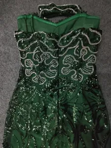 Makro-Detail der schweren Perlen- und grünen Paillettenstickerei auf Abendkleid