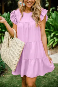 Detail view of a summer tiered pleated dress with flutter ruffled sleeves in a soft pink hue
