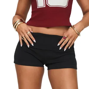 Close-up of black slim-fit yoga shorts with a fold-over high waistband for fitness.