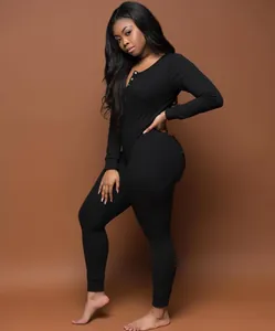 Detail view of a black long-sleeved pajama jumpsuit with button neckline and slim fit
