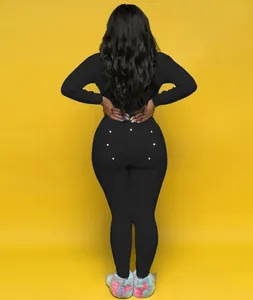 Back view of black long sleeve jumpsuit featuring functional buttoned drop seat flap.