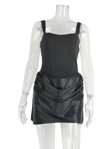 Front view of black strappy mini dress with draped skirt on clear mannequin