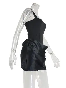 Detail view of a black strapless mini dress with ruffled satin skirt on a mannequin.