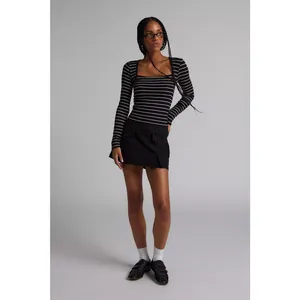 Model wearing a black and white striped ribbed long sleeve top with a low neckline