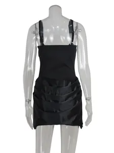 Back view of a black satin mini dress with thin straps and layered pleated skirt design