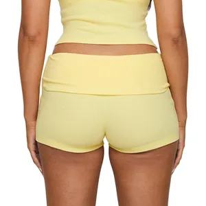 Back view detail of yellow high-waisted yoga shorts with fold-over waistband design