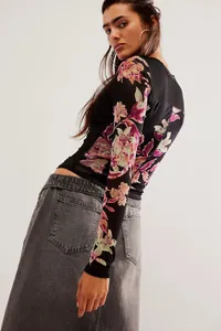 Vue détaillée du haut à manches longues en résille pour femme avec motif floral.