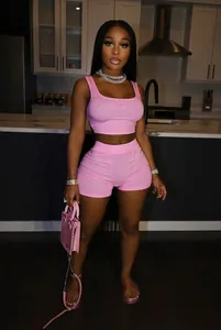 Fashionable pink two-piece set featuring a crop top and tight shorts shown on a model
