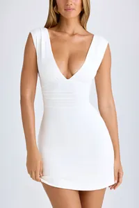 Close-up of white sleeveless bodycon dress featuring deep V-neck and elegant ruched waist detail.