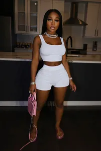Detailed view of the white two-piece workout set featuring a crop tank and mini shorts
