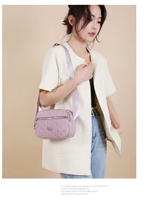 Detailansicht einer lila gesteppten Oxford-Umhängetasche für Damen mit Freizeitoutfit