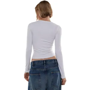 Detailed back view of a slim-fit white ribbed long-sleeve top and blue denim jeans