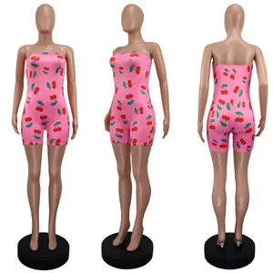 Close-up detail of a pink strapless slim-fit romper with an all-over red cherry print