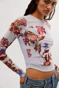 Détail du tissu en mesh transparent et imprimé floral sur un haut ajusté à manches longues