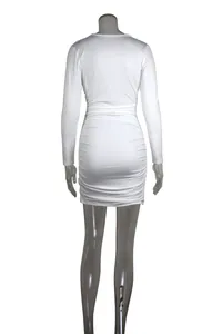 Back view showing the ruching detail of a white long-sleeved bodycon mini dress on mannequin.