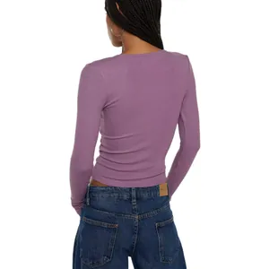 Back view of a slim-fit purple rib-knit long-sleeved top paired with blue denim jeans