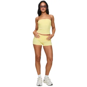 Full body studio shot of a light yellow tube top and high-waist fold-over shorts set