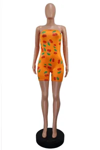 Detail shot of a women's sexy strapless orange romper with repeating red cherry print pattern
