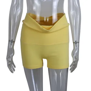 Close-up detail of yellow cotton yoga shorts featuring a stylish fold-over waistband