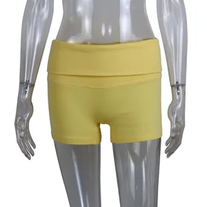 Close-up of yellow ribbed yoga shorts with high-waist fold-over design on mannequin