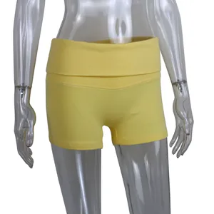 Detail view of yellow ribbed cotton yoga shorts featuring a high-rise turnover waistband design