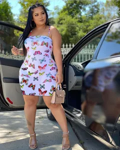 Curvy model posing in a white butterfly print camisole bodycon mini dress next to a car