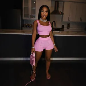 Women's pink two-piece sports set with crop top and tight shorts