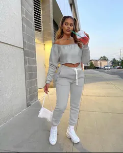 Full shot of women's off-the-shoulder grey tracksuit set presented in an urban setting