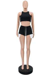 Two-piece women's activewear set with black crop top and white slit detail shorts