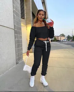 Street style view of woman wearing black off-the-shoulder sweatshirt and sweatpants set