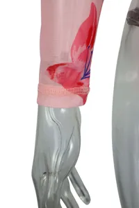 Gros plan d'une manche en maille rose avec imprimé floral rouge et détails de couture.