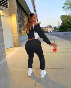Detail of a black off-the-shoulder two-piece sweatsuit for women in a street setting