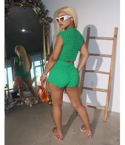 Modelo con un conjunto verde de dos piezas con textura de burbuja, crop top y pantalones
