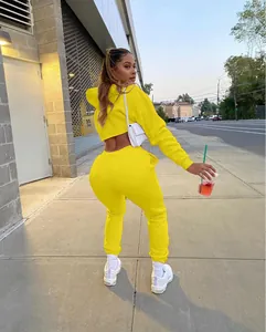 Back view of vibrant yellow two-piece cropped hoodie and sweatpants set shown on model