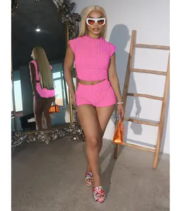Modelo de moda con un vibrante conjunto rosa de top corto y pantalones cortos