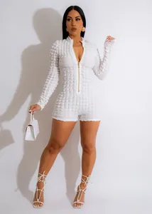 Full body shot of a white bubble textured knit long sleeve rompers with V-neck zipper detail