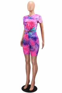 Side view of vibrant tie-dye 2 piece workout set with knotted crop top and shorts