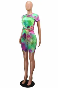 Side view of vibrant green and pink tie-dye two-piece athletic crop top and short set