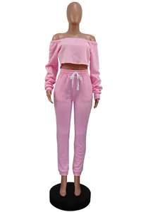 Pink off-the-shoulder fleece crop top and matching sweatpants two-piece tracksuit set.
