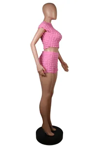 Vista lateral del conjunto de dos piezas rosa para mujer con top corto y shorts texturizados
