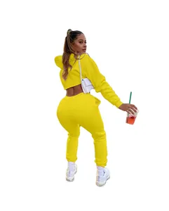 Back view of woman wearing bright yellow fleece hoodie and jogger two-piece set