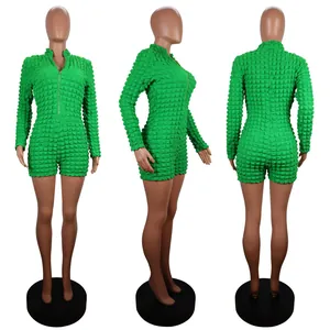 Detailed views of green textured bubble grid jumpsuit with front zipper closure