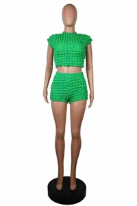Detalle de un conjunto de dos piezas verde con top corto y pantalones con textura de burbuja
