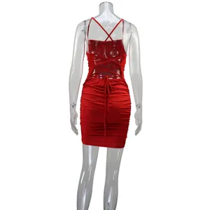 Back view of a red ruched bodycon dress with crisscross lace-up straps on a mannequin
