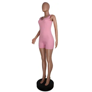 Macro view of a pink ribbed knit romper on a mannequin, highlighting the U-neck and fabric texture.