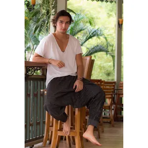 Detailed view of men's loose drop-crotch harem pants with ethnic patterns