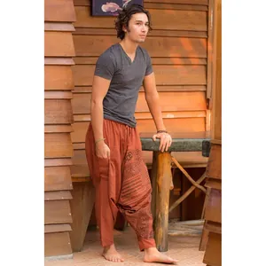 Full-body view of men's rust-colored harem pants with ethnic print and Om symbol