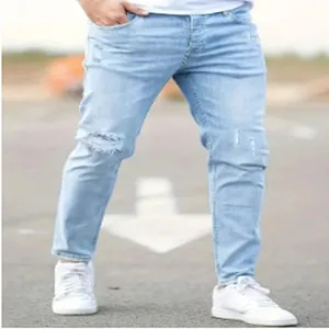 Vista dettagliata dei jeans skinny consumati azzurri da uomo abbinati a sneaker bianche.
