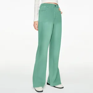 Detail view of high-waist mint green straight-leg trousers with button closure.