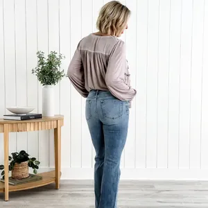 Vista posteriore di eleganti jeans a zampa blu a vita alta da donna in un contesto lifestyle